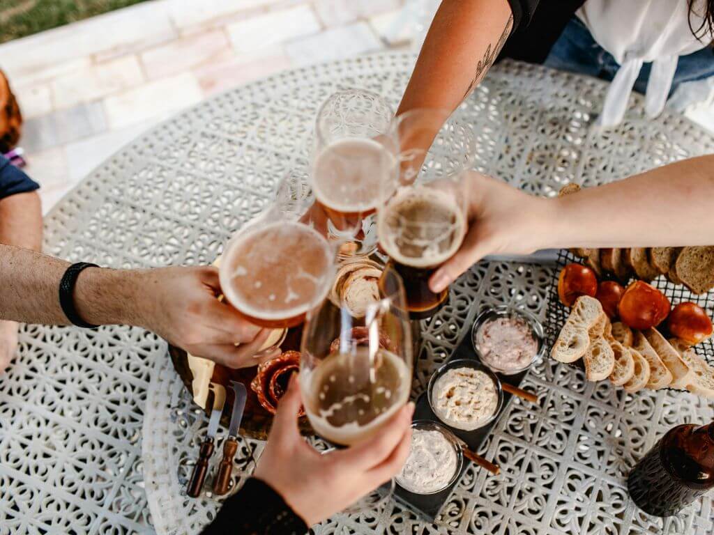 Friends celebrating around a snack table with dips, bread and grazing board items