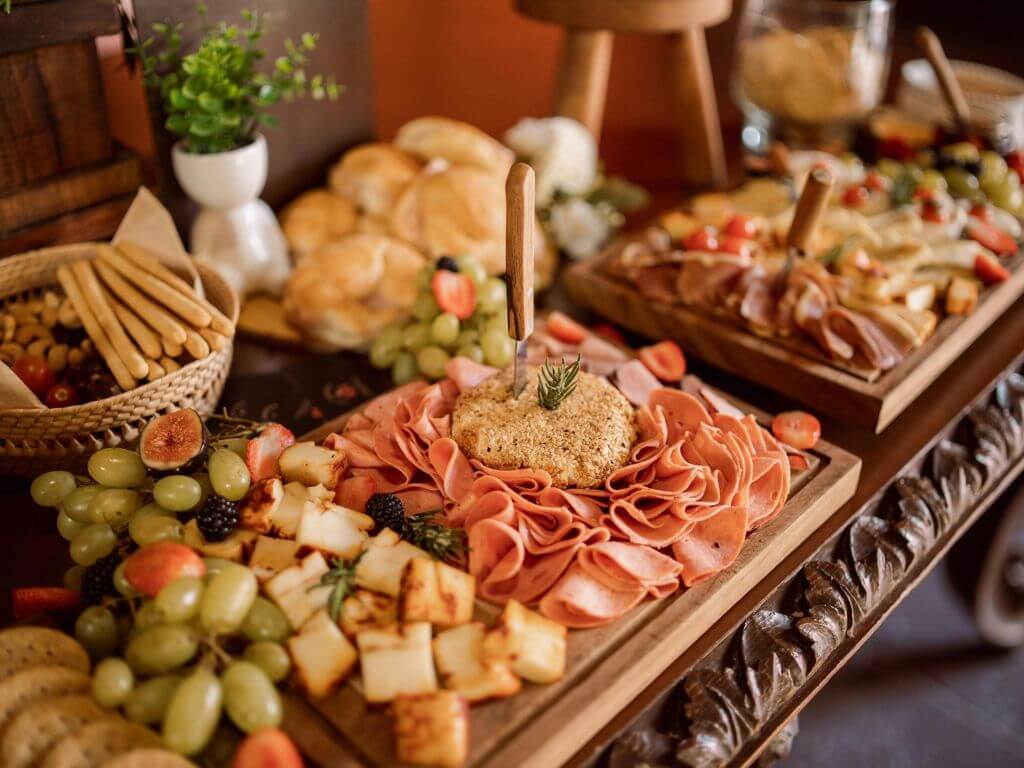 Festive grazing board featuring ham slices, cheese cubes, grapes and assorted crackers