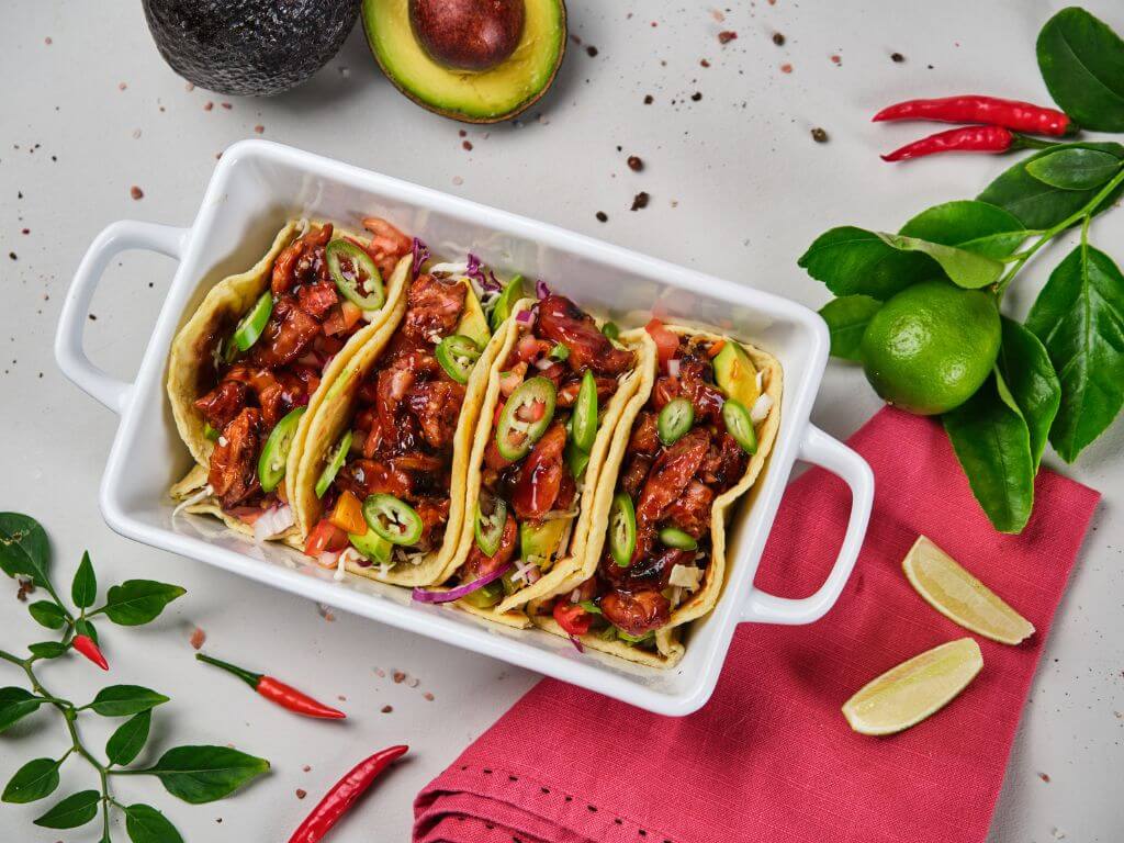 Frey’s rib tacos in serving dish with lime, chilli and herbs.